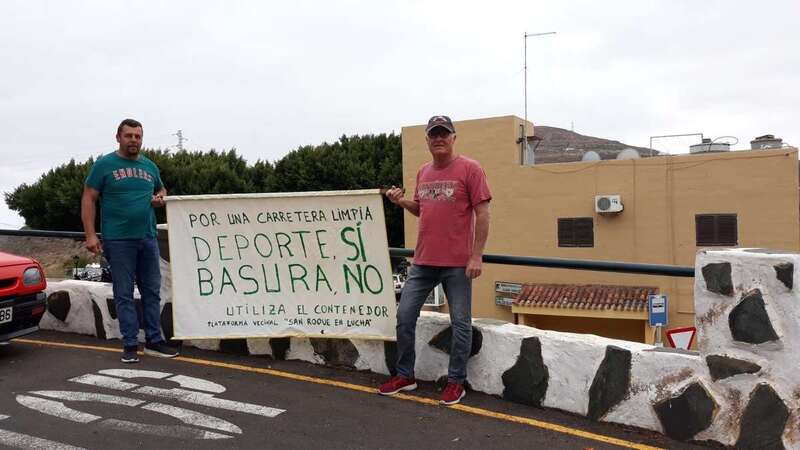 Dos vecinos lucen una pancarta con el lema Deporte, sí. Basura, no (Foto TA)